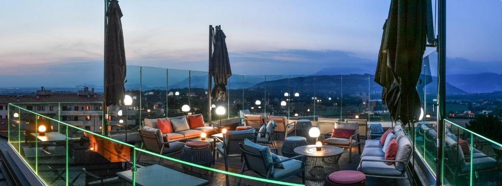 Un balcón con sillas y mesas en un edificio en Panorama Hotel Friuli - Boutique Hotel, en San Daniele del Friuli
