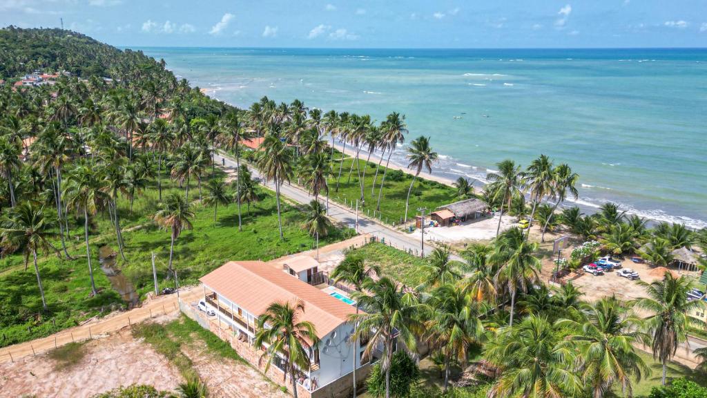 an aerial view of a beach with palm trees at Pousada Estação do Mar in Japaratinga