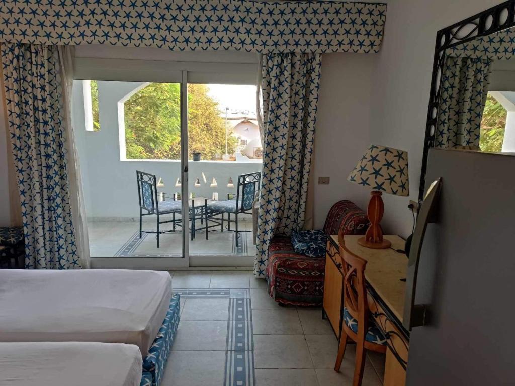 - une chambre avec un lit, un bureau et un balcon dans l'établissement Camera Aqua marin centralissima, à Charm el-Cheikh