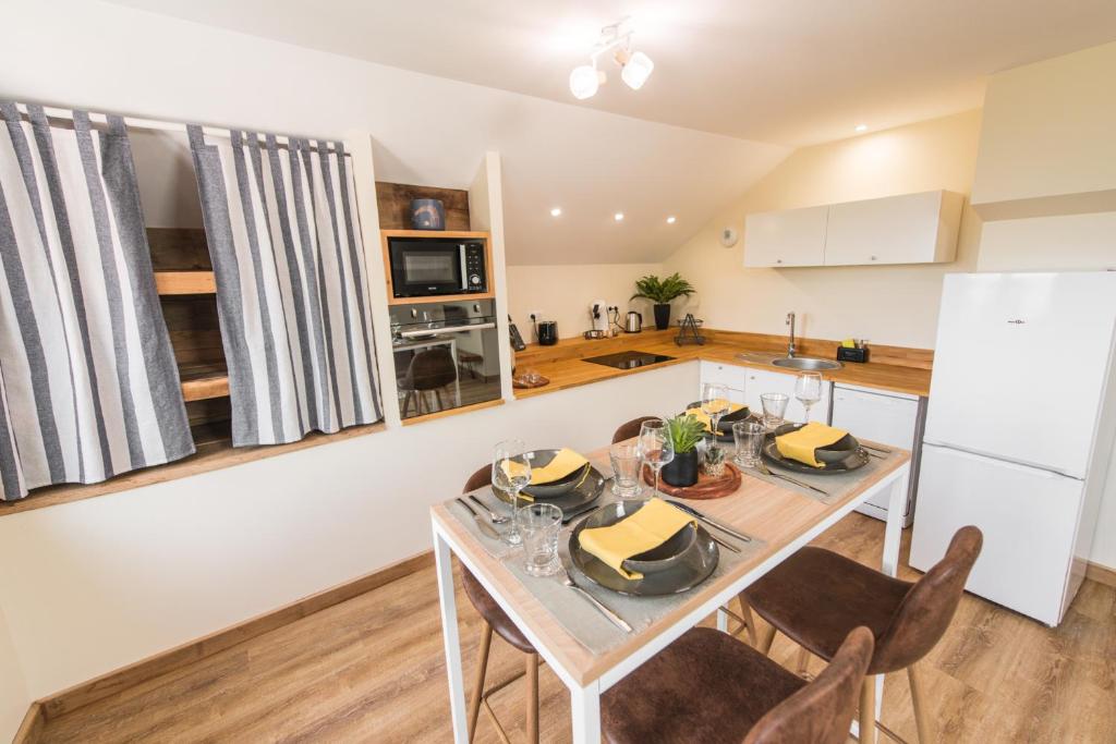 eine Küche und ein Esszimmer mit Tisch und Stühlen in der Unterkunft Le Milan Royal - Montmin in Montmin