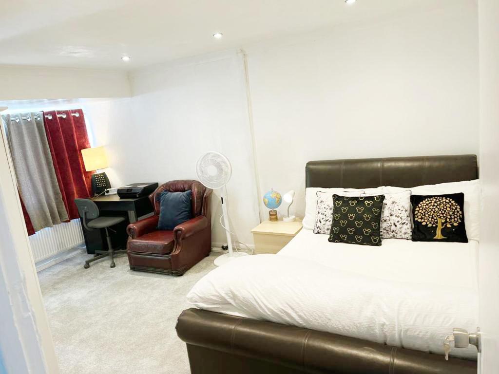 a bedroom with a bed and a chair and a desk at Khan's Living Lakeside Drive Cyncoed Cardiff in Cardiff