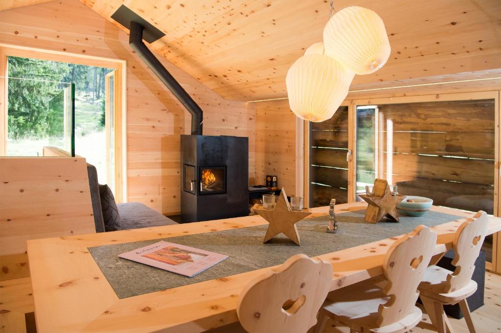 a log cabin dining room with a table and a fireplace at Mountain Cabin Got Spess Lenzerheide in Obervaz
