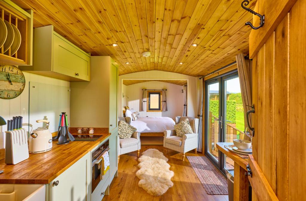 - une cuisine et un salon avec un lit dans une chambre dans l'établissement Abberley Shepherds Hut - Ockeridge Rural Retreats, à Wichenford