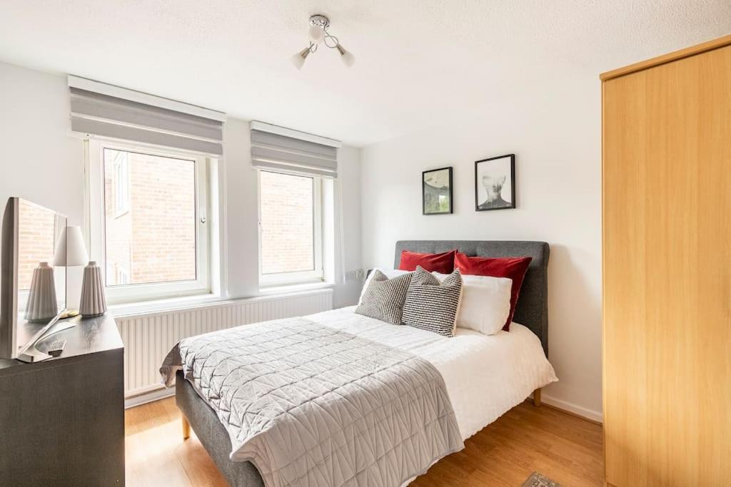 - une chambre avec un grand lit et des oreillers rouges dans l'établissement 2 BDR - Entire Flat - Central London, à Londres
