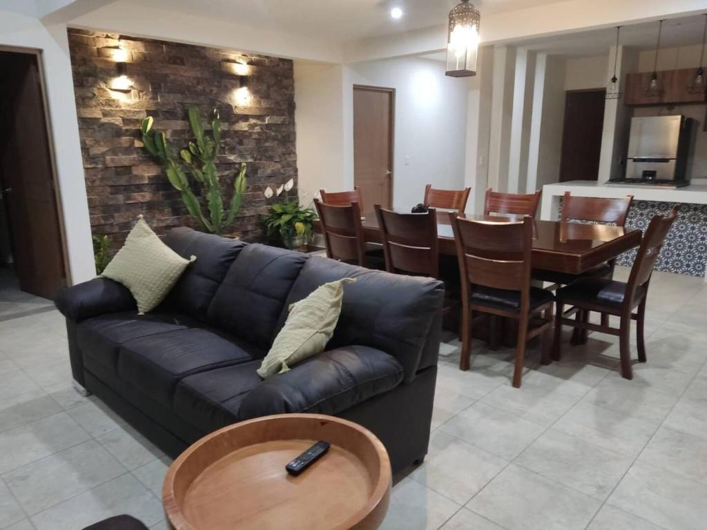- un salon avec un canapé en cuir noir et une table dans l'établissement Casita En Patzcuaro, à Pátzcuaro