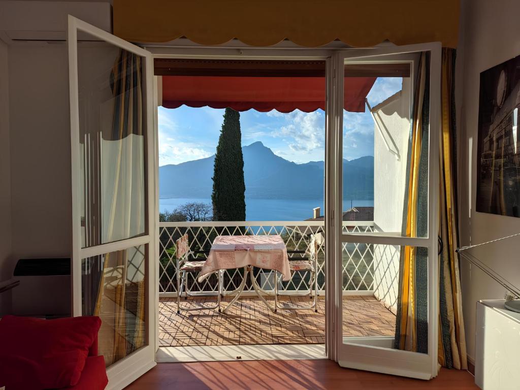 - une porte donnant sur un balcon avec vue sur l'océan dans l'établissement Garda Panoramic House, à Torri del Benaco