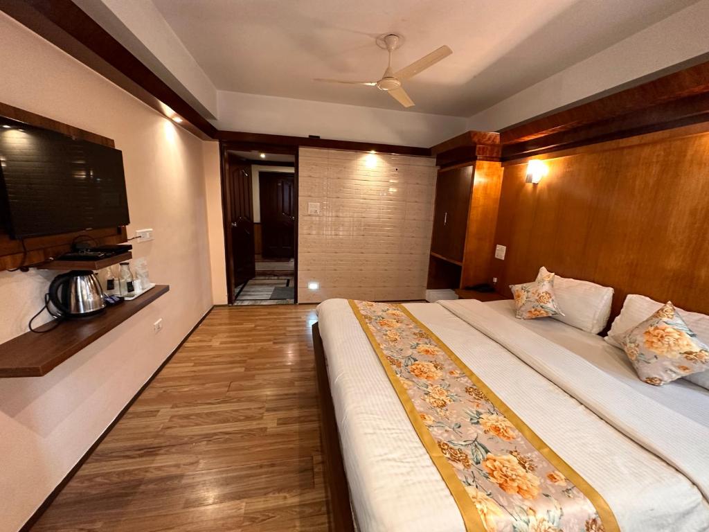- une chambre avec un grand lit et une tête de lit en bois dans l'établissement Hotel Gajraj, à Gangtok