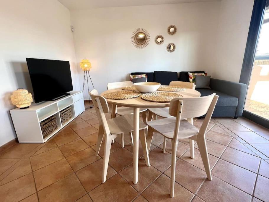 een woonkamer met een tafel en stoelen en een bank bij Dreamsville Fuerteventura a 5 minutos de Lajares in Lajares
