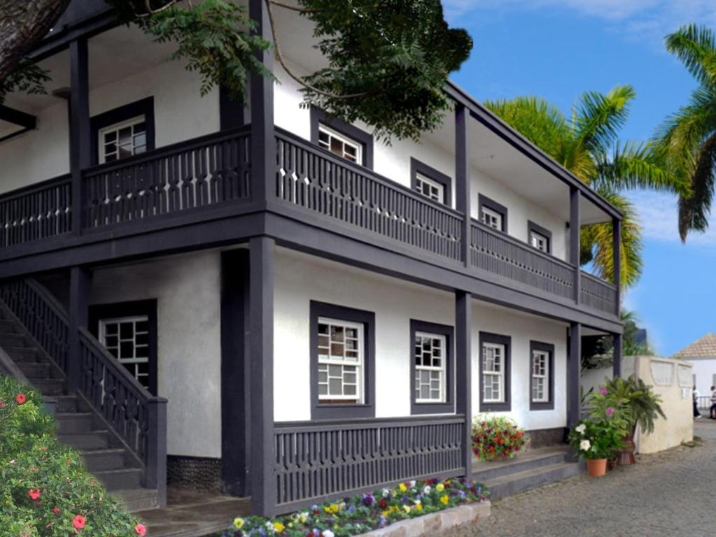 ein weißes und schwarzes Haus mit einem Balkon in der Unterkunft Hotel POUSADA Brava in Vila Nova Sintra