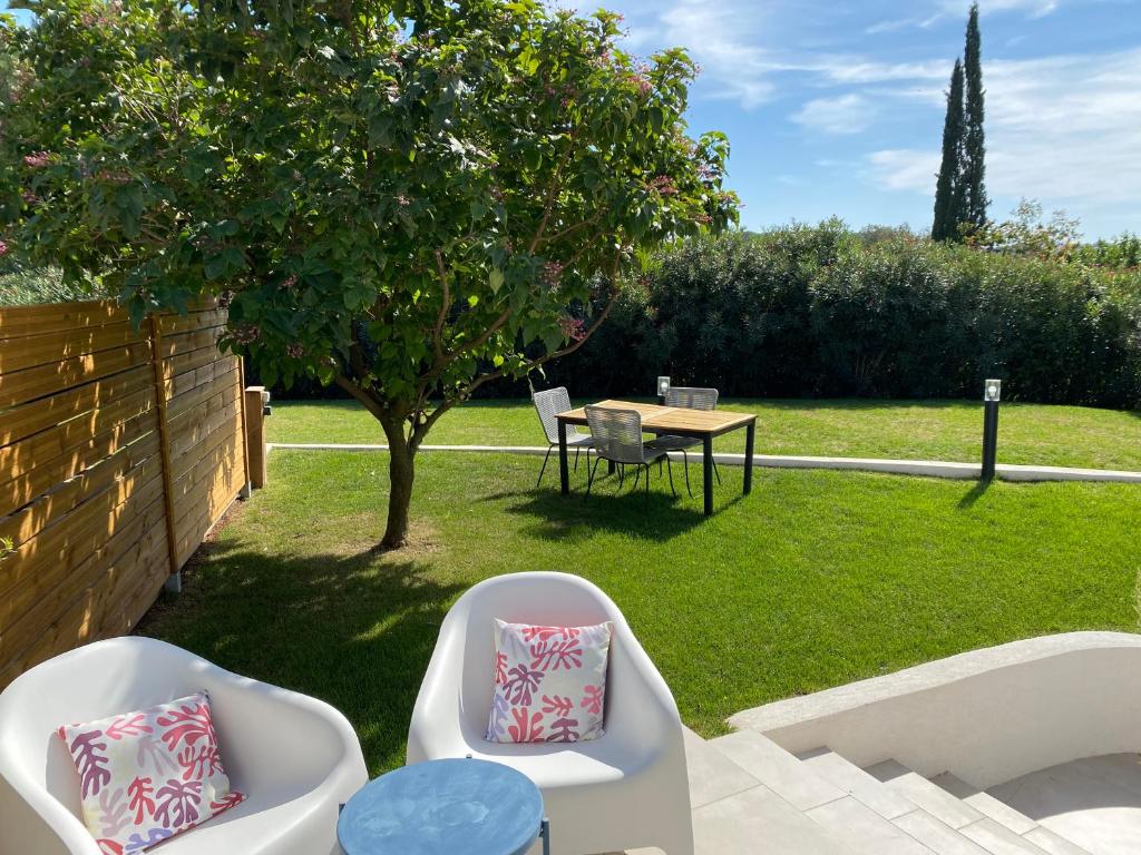 un giardino con tavolo, sedie e un albero di Logement indépendant dans villa avec jardin a Ventabren