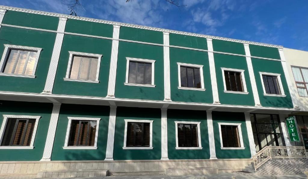 un edificio verde y blanco con ventanas blancas en HOTEL MRT en Mingachevir