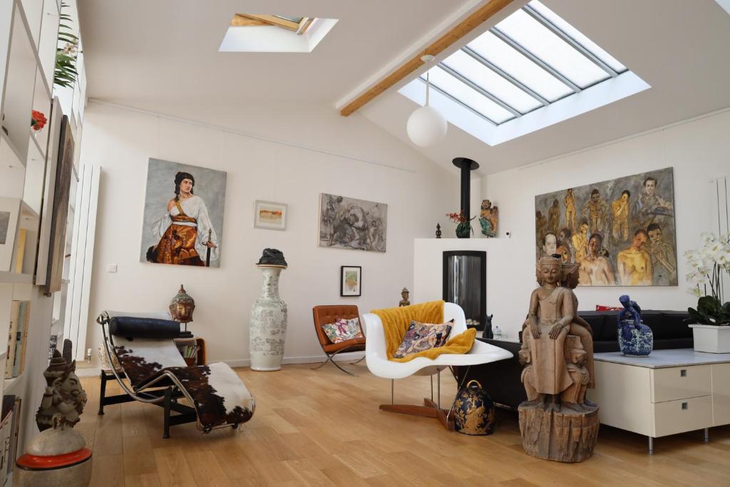 - un salon avec une lucarne et beaucoup d'art dans l'établissement Loft, atelier artiste Montmartre, à Paris