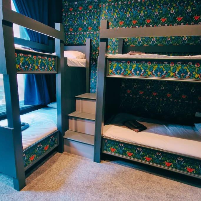 a room with three bunk beds in a room at The Queen Street Bunkhouse in Newcastle upon Tyne