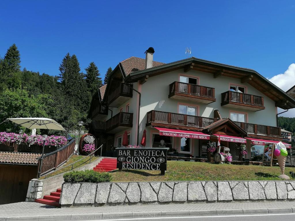 un grande edificio con un cartello di fronte di Giongo Residence Aparthotel 103 a Lavarone