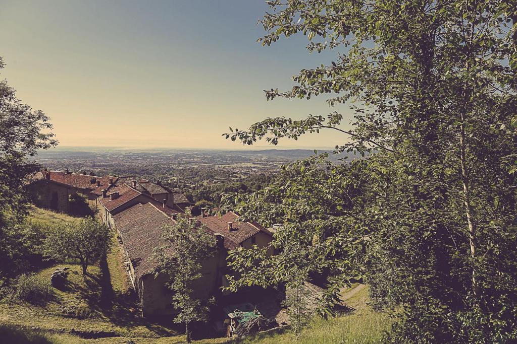 vistas a una ciudad desde una colina con árboles en Relais di charme Frazione Chiavolino, en Pollone