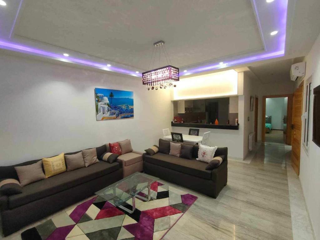 uma sala de estar com um sofá e uma mesa de vidro em Dar Al Yaqout em Le Kram