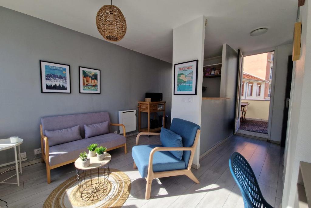 uma sala de estar com um sofá, cadeiras e uma mesa em View on the Bastille Center Terrace All equipped #E0 em Grenoble