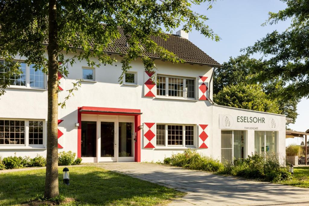 een uitzicht op een wit gebouw met rode accenten bij Schloss Hertefeld & Hertefeldhof in Weeze