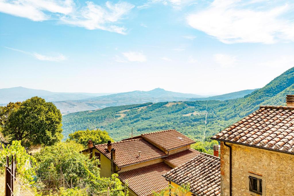 a view of two houses with mountains in the background at Casa vacanze Val d'orcia in Campiglia dʼOrcia