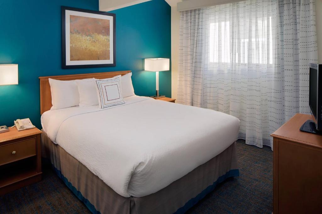 1 dormitorio con 1 cama grande y pared azul en Residence Inn Shelton Fairfield County, en Shelton