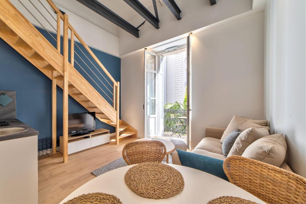 a living room with a couch and a table and chairs at Appartement Croisette Cannes centre in Cannes