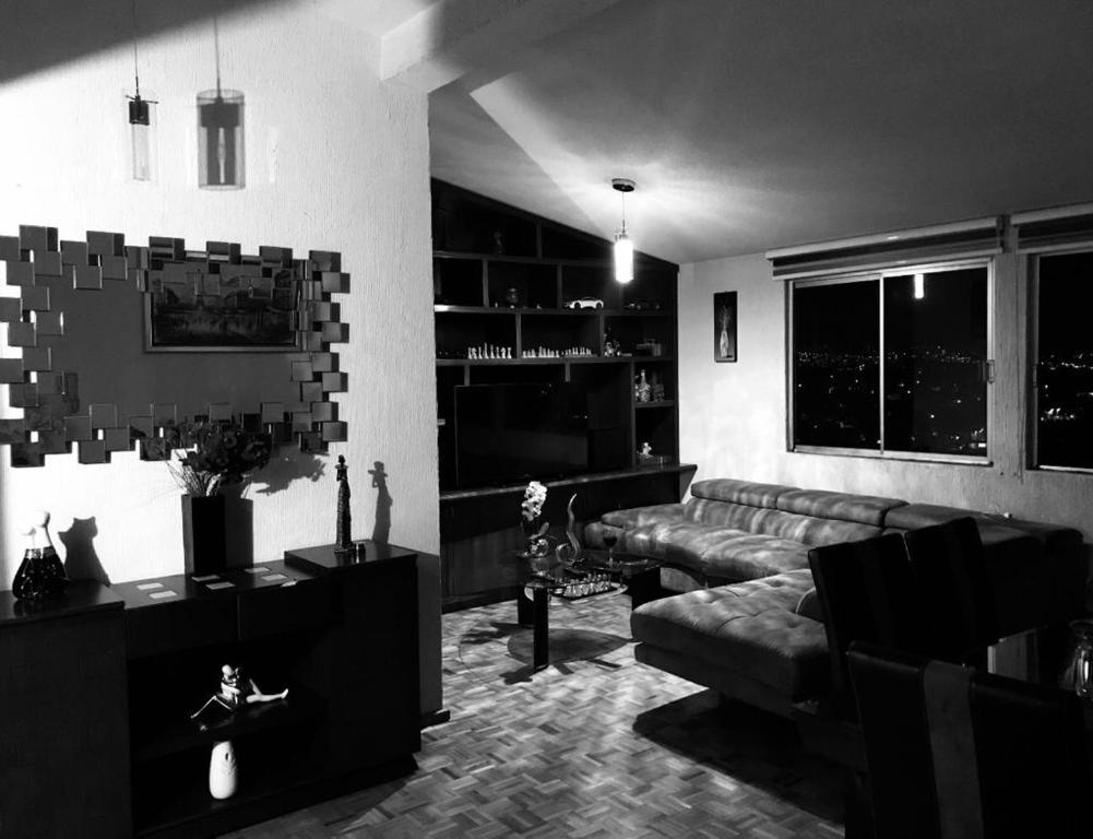 ein Wohnzimmer mit einem Sofa und einem Tisch in der Unterkunft DEPARTAMENTO CON VISTA HERMOSA A 5 MIN DE SIX FLAGS in Mexiko-Stadt
