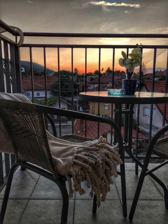 a table and chair on a balcony with a sunset at Soko City Center & Parking Free in Soko Banja