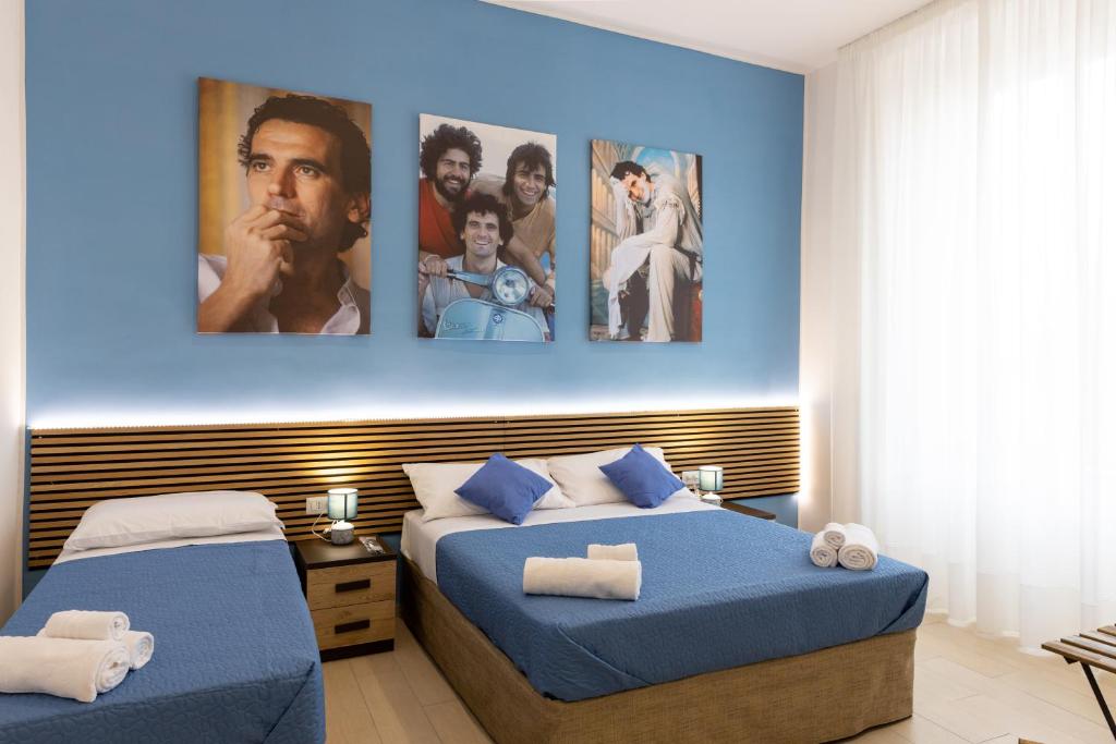2 letti in una camera con poster appesi al muro di The HeArt Guest House a Napoli