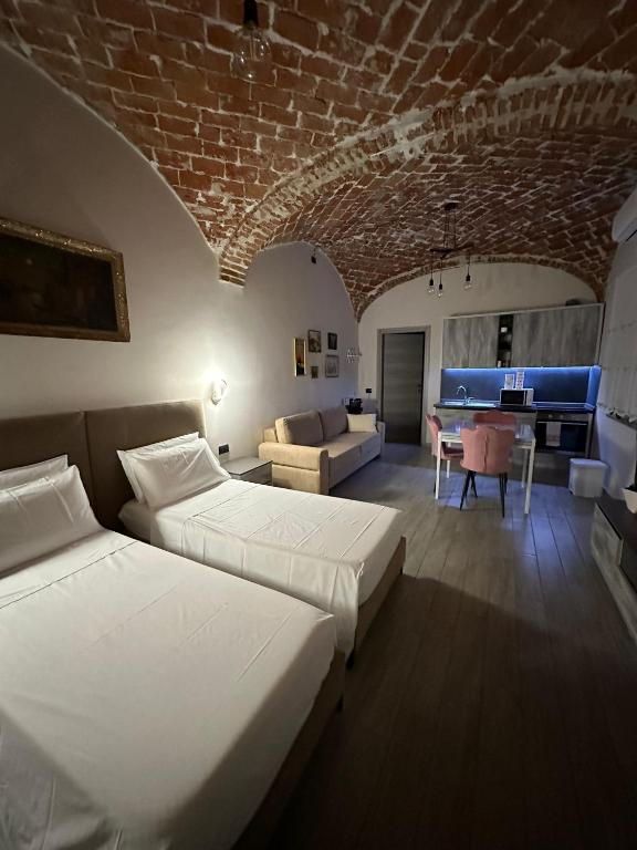 una camera con 2 letti e un soggiorno con divano di Residenza Zotaj Small appartament a Casale Monferrato