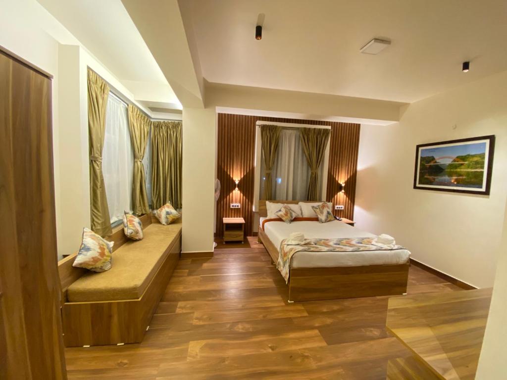Habitación de hotel con cama y sofá en Janeira en Shillong
