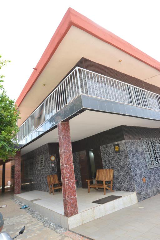 a house with a balcony on top of it at Résidence Les 6 Roses in Porto-Novo
