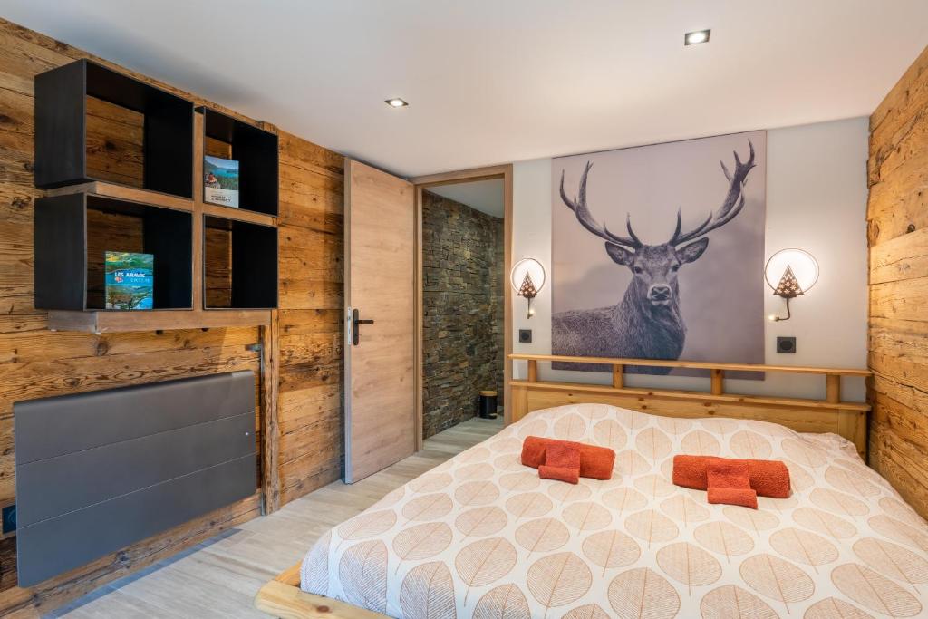 um quarto com uma cama e uma pintura de veado na parede em Appartement chaleureux, massif des Aravis em Entremont