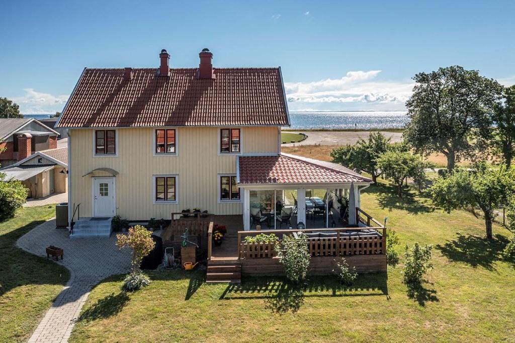 een klein huis met een veranda en een terras bij Hus nära havet in Bergkvara