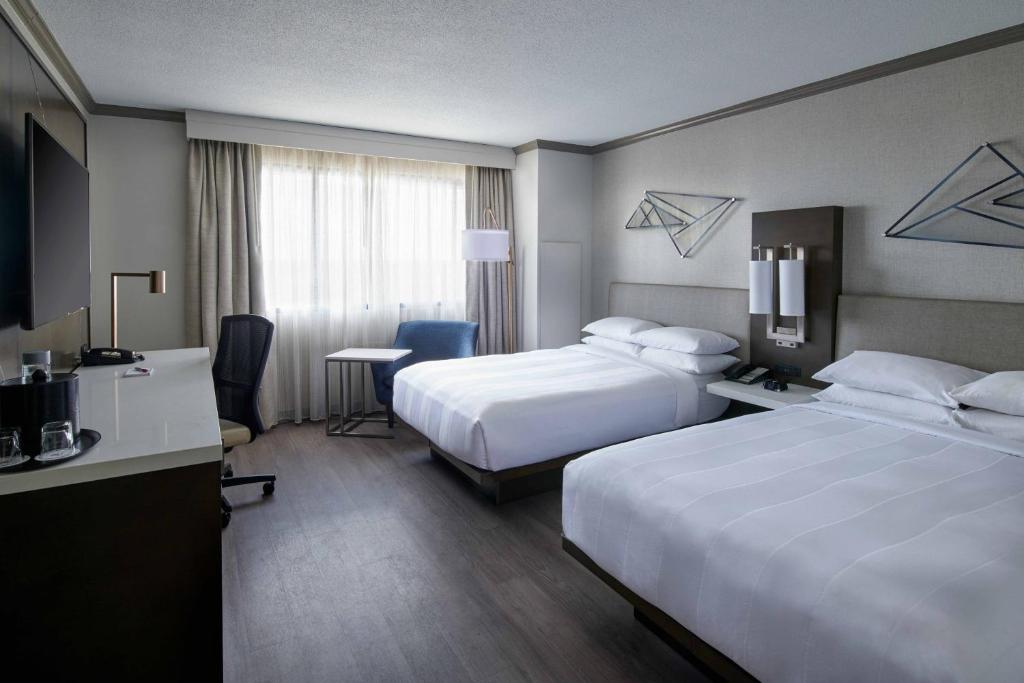 a hotel room with two beds and a desk at Detroit Marriott Troy in Troy