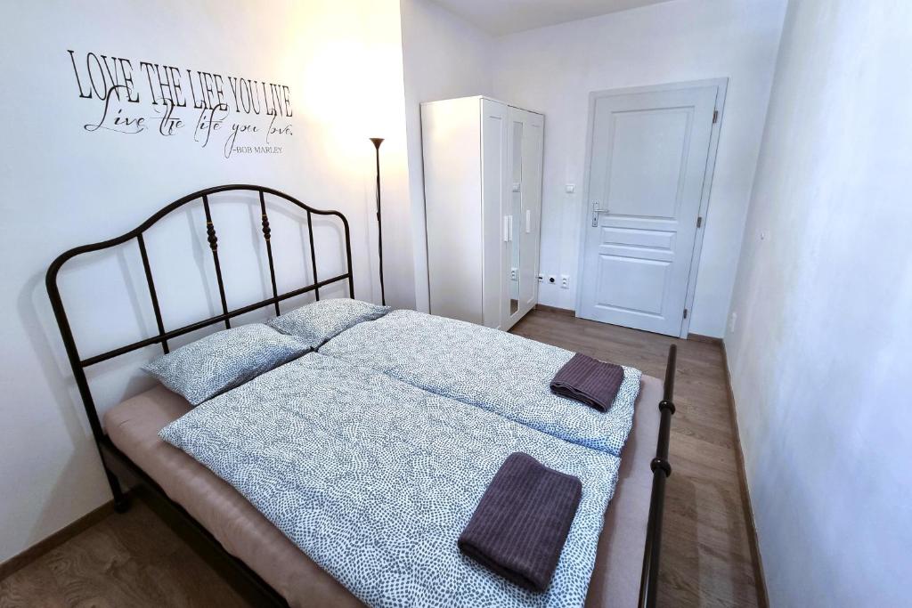 ein kleines Schlafzimmer mit einem Bett mit einer blauen Decke in der Unterkunft Cozy APT near CityCenter w/ great public transport in Staré Mesto