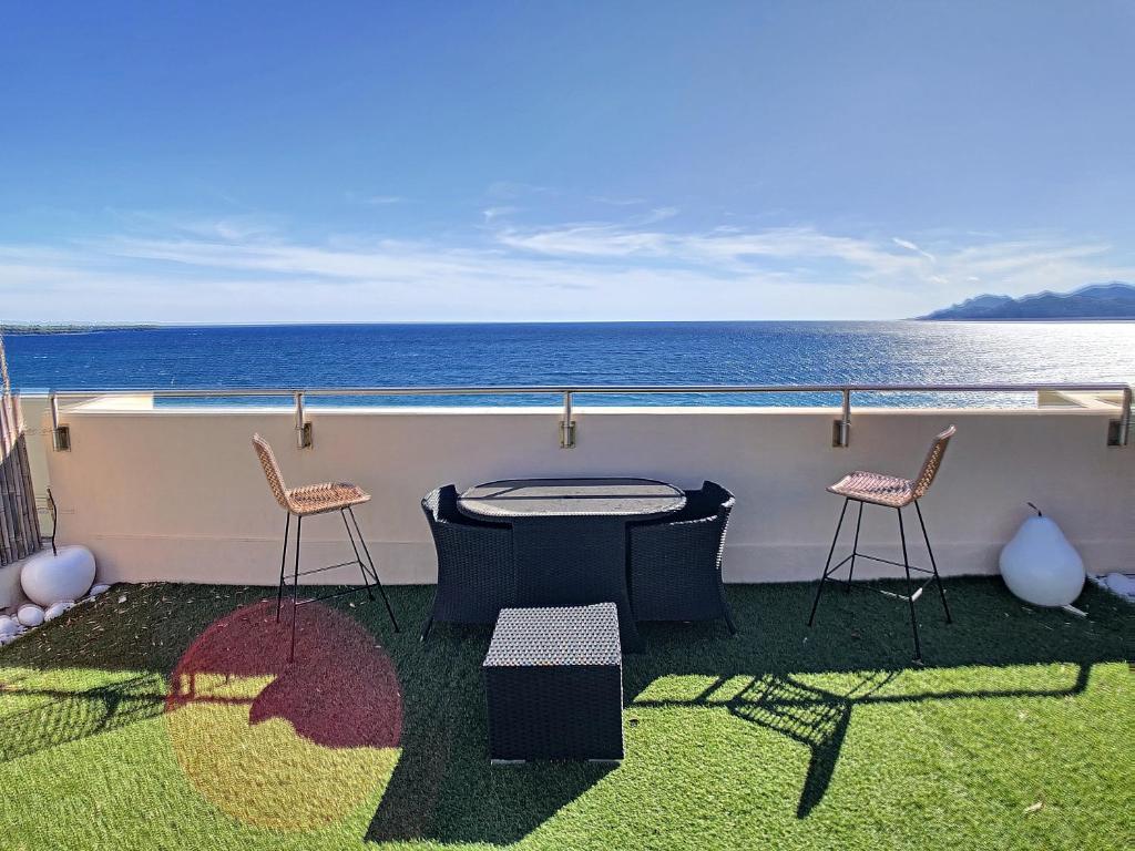 uma varanda com uma mesa e cadeiras e o oceano em Beach Penthouse with unique rooftop terrace 301 em Cannes