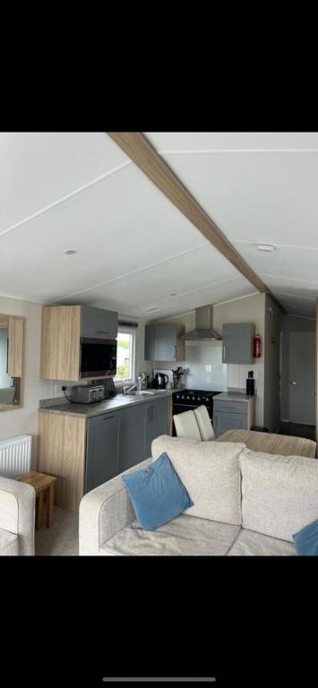 a living room with a couch and a kitchen at White tower holiday park in Caernarfon