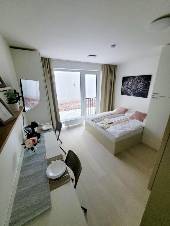 a bedroom with a bed and a table with chairs at Garden apartment Brno center in Brno