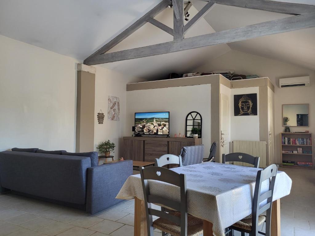 a living room with a table and a couch at Maison au calme Avignon - Clim - Wi-Fi in Avignon