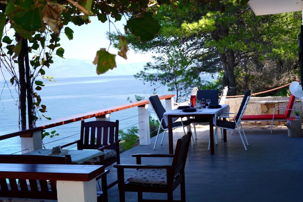 een tafel en stoelen op een balkon met uitzicht op de oceaan bij Beach House Hvar in Zastražišće