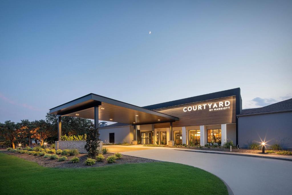 a view of a building with a court yard at Courtyard Dallas Addison Midway in Addison