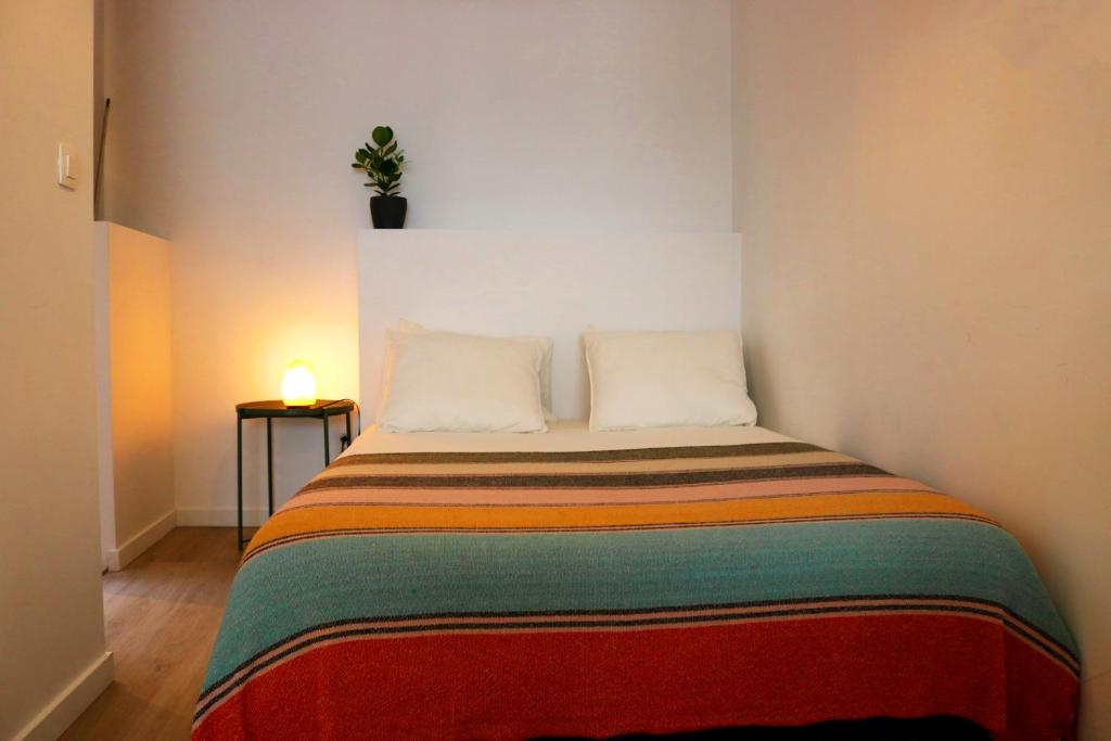 a bed with two pillows and a plant on the wall at Studio Sous - Sea, Sun, City-Centre in Ostend