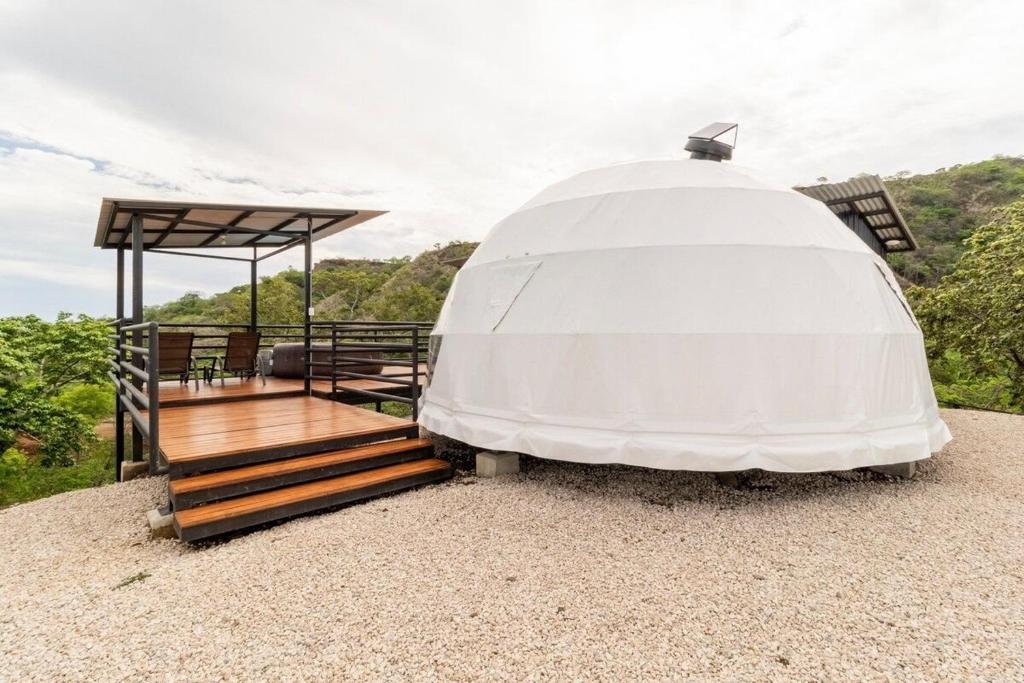 a dome house with a staircase and a deck at Glamping en Playa Potrero in Potrero
