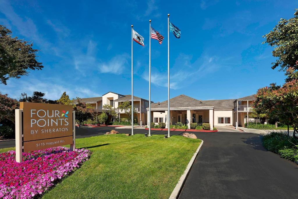 a sign for four points by sheraton with two flags at Four Points by Sheraton - Pleasanton in Pleasanton