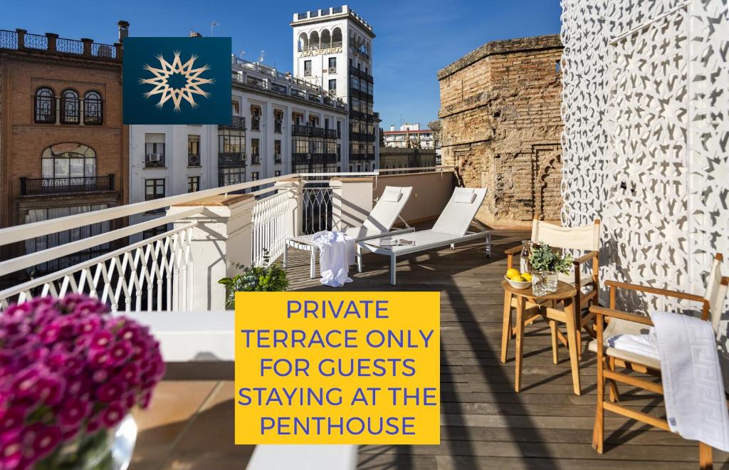 a sign on top of a balcony with chairs and a building at Torre Homenaje Historical Suites in Seville