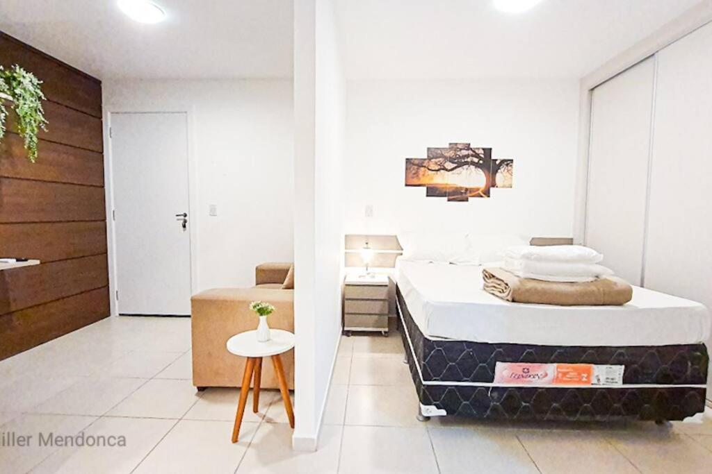 a bedroom with a bed and a small table at Encantador Refúgio Completo e Bem Localizado in Campos dos Goytacazes