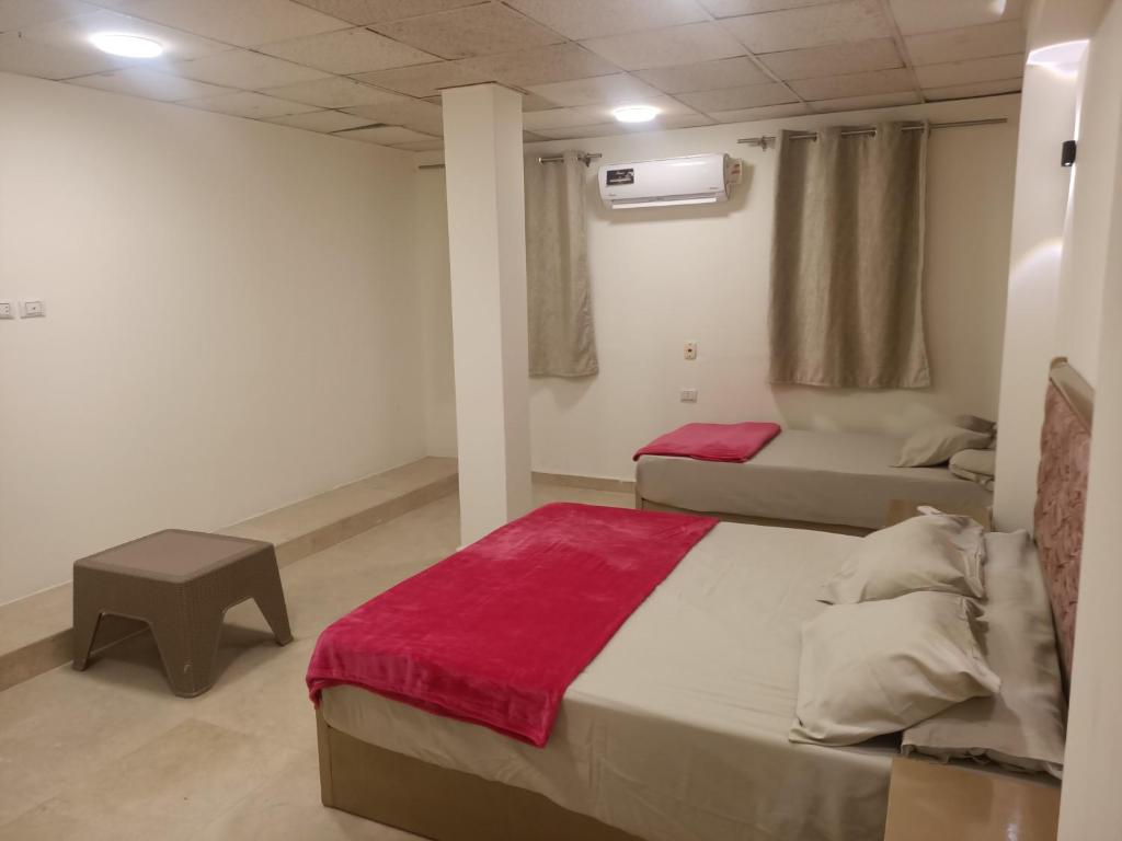 ein Schlafzimmer mit 2 Betten und einem Tisch darin in der Unterkunft El jawhra house in Kairo