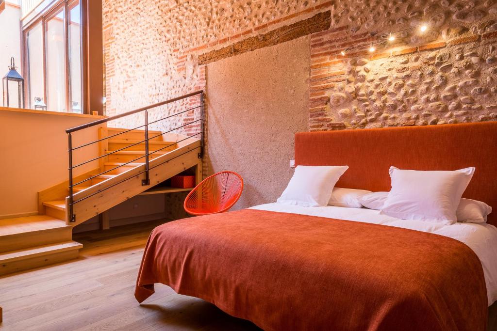 a bedroom with a large bed with a staircase at Mas Latour Lavail in Perpignan