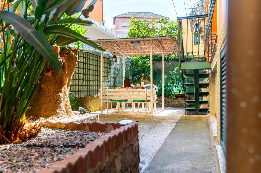 um pátio com uma mesa e um banco num quintal em Maison d' Ofelia em Chiavari