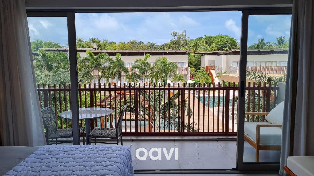 a bedroom with a balcony with a view of a pool at Qavi - Luxo Rua Principal de Pipa #ÎledePipa in Pipa